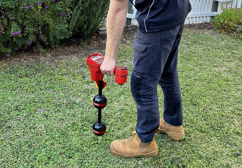 Tap Tech plumber using a RIDGID locator wand to pinpoint tree roots on a Perth lawn