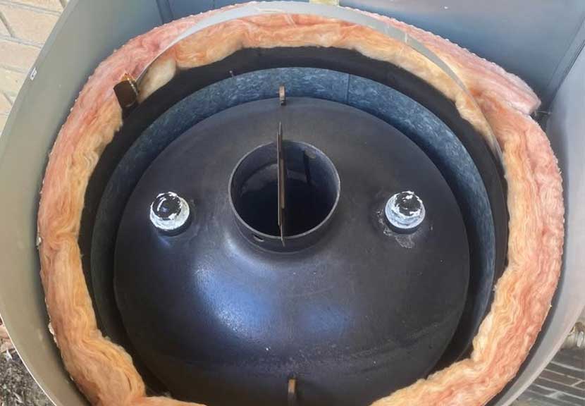 Open gas hot water tank casing showing insulation and components during a scheduled service