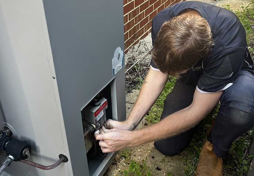 Tap Tech technician servicing a gas hot water unit in Perth