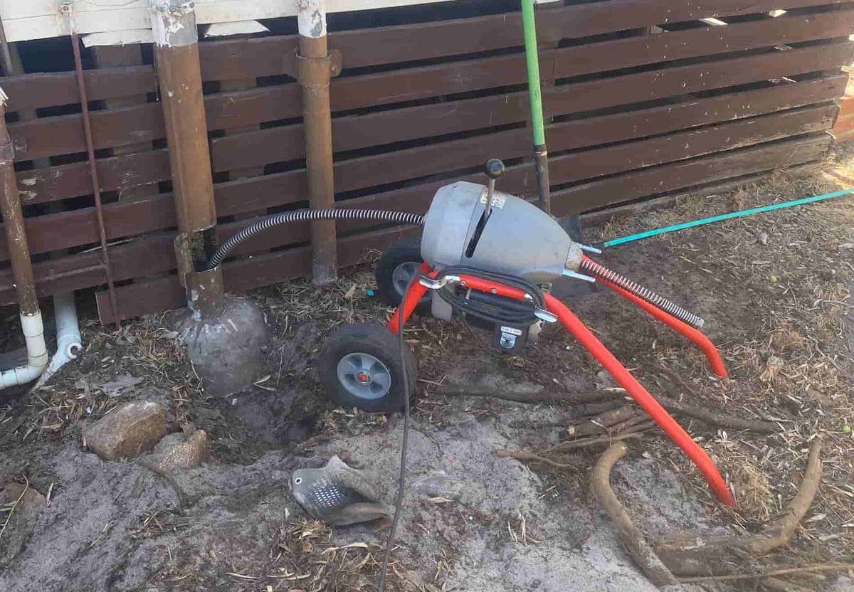 Rigid drain snake set up ready to clear a blocked sewer line