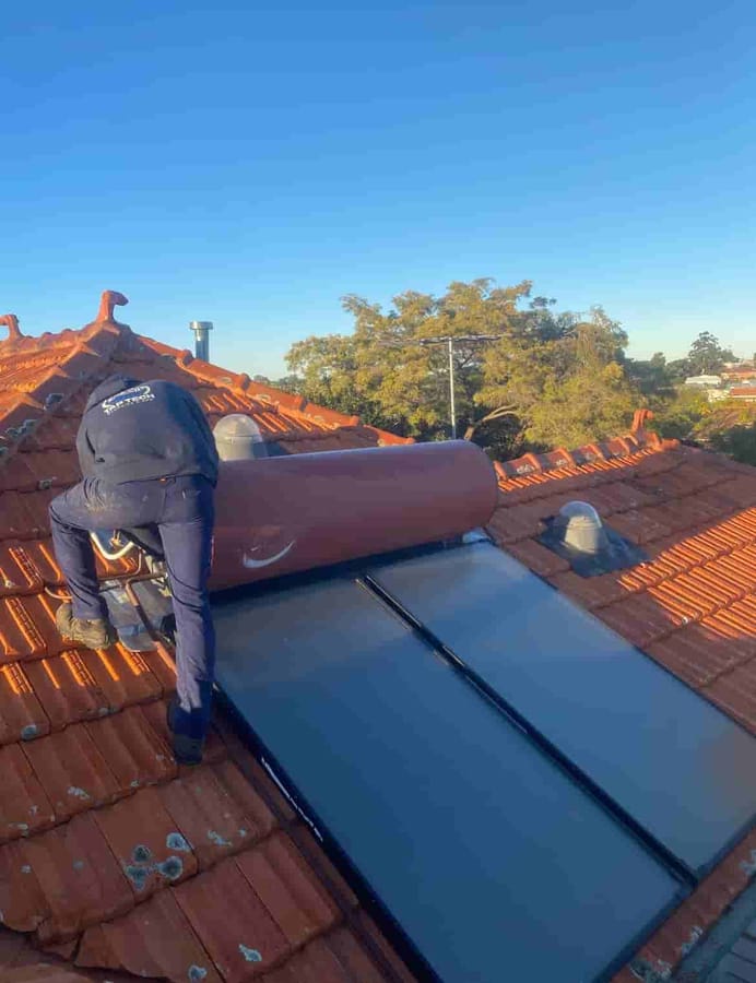Tap Tech technician repairing a solar hot water system on a Perth roof